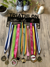 Load image into Gallery viewer, Triathlon medal holder with medals. swim, cycle, run figures and text at top. matt black 6 bars